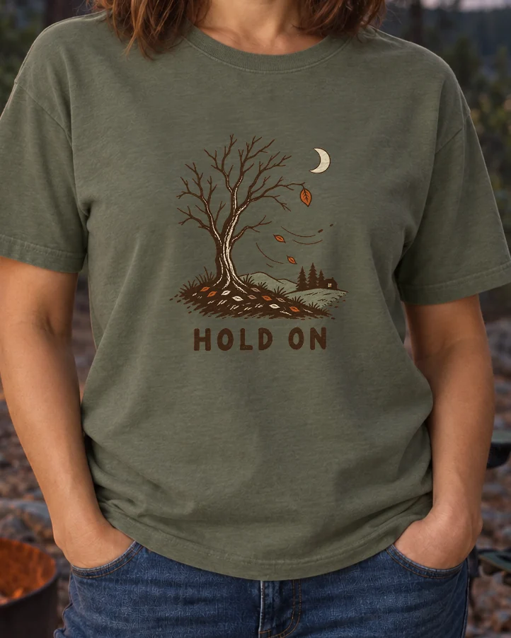 AI-generated image of a fictional model wearing the Hold On Tee in Moss, size M, at 5′4″ tall, cropped to the print.