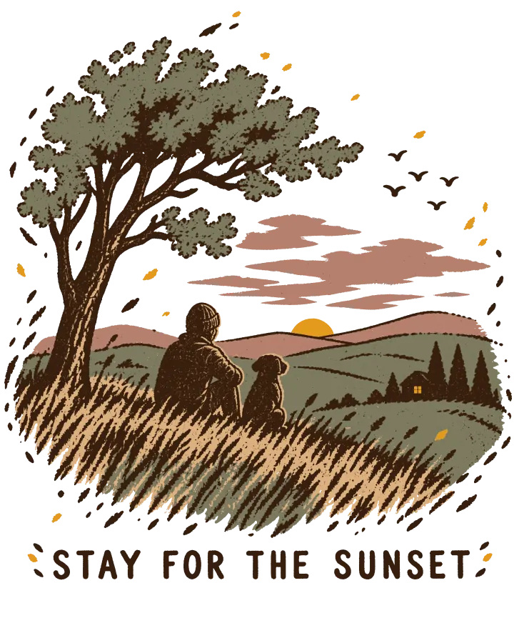 Print artwork: a person and a small dog sitting side by side on a grassy hill, seen from behind, watching the last of the sun go down over rolling hills with pines and a small house. A windblown tree leans over them, birds cross a pink sky, and the grass is lit gold. Below, in spaced brown capitals: Stay for the sunset.